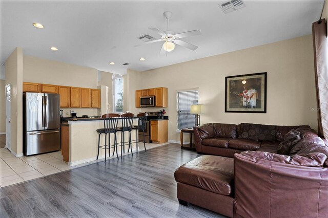 living room featuring ceiling fan and light hardwood / wood-style floors