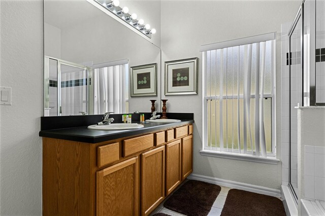 bathroom featuring tile patterned flooring, vanity, and walk in shower