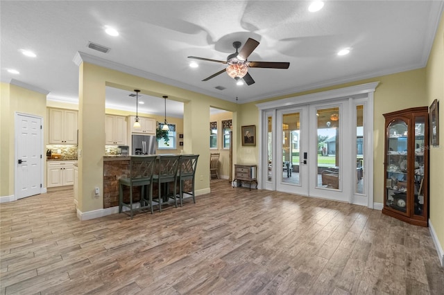 kitchen with french doors, hanging light fixtures, stainless steel refrigerator with ice dispenser, crown molding, and light hardwood / wood-style floors