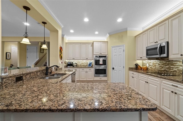 kitchen with sink, backsplash, crown molding, dark stone counters, and appliances with stainless steel finishes