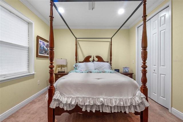 carpeted bedroom with crown molding and a closet