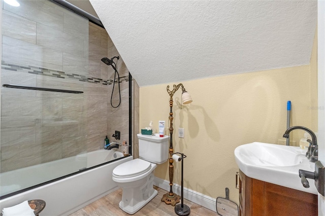 full bathroom with combined bath / shower with glass door, a textured ceiling, vaulted ceiling, hardwood / wood-style floors, and toilet