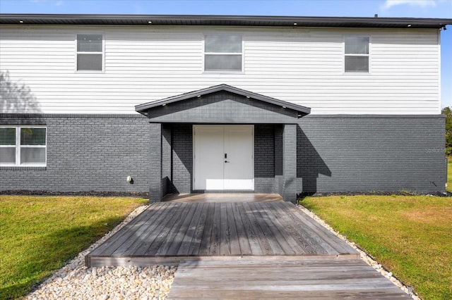 exterior space with a wooden deck and a lawn