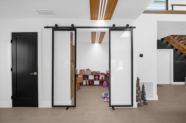 interior space featuring a barn door and light hardwood / wood-style flooring