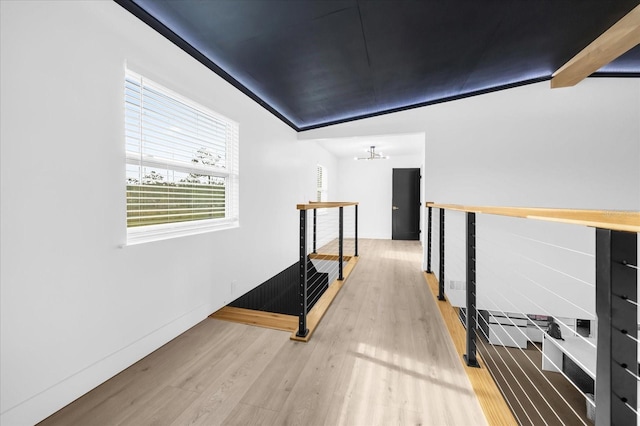 hallway with lofted ceiling with beams, light hardwood / wood-style floors, and a notable chandelier