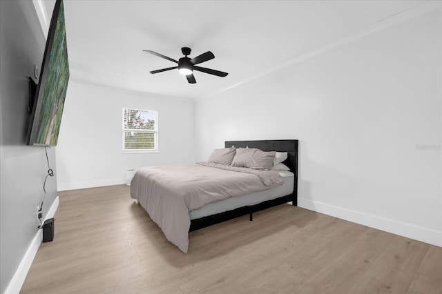 bedroom with ceiling fan, light hardwood / wood-style floors, and ornamental molding