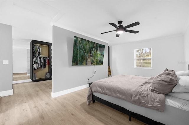 bedroom with a closet, ceiling fan, crown molding, and light wood-type flooring