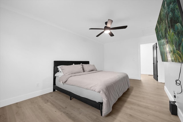 bedroom with light hardwood / wood-style flooring, ceiling fan, and ornamental molding