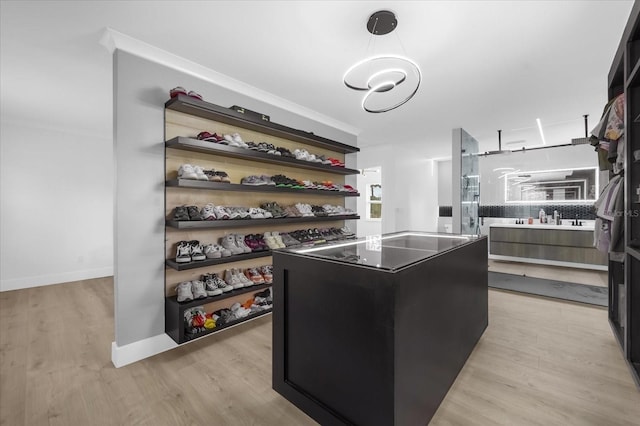 walk in closet with light hardwood / wood-style flooring