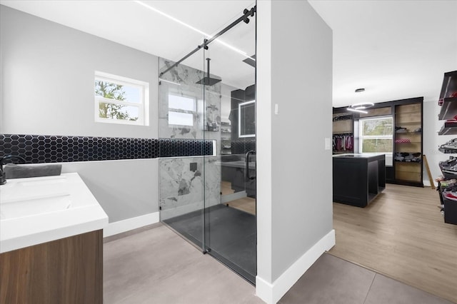 bathroom featuring vanity, hardwood / wood-style flooring, plenty of natural light, and a shower with shower door