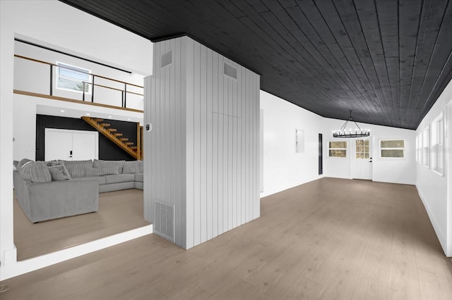 hallway with a chandelier, light hardwood / wood-style flooring, lofted ceiling, and wood ceiling