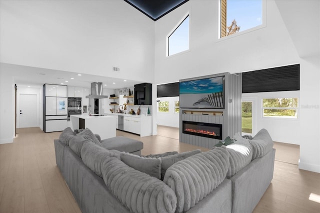 living room with a high ceiling and light wood-type flooring