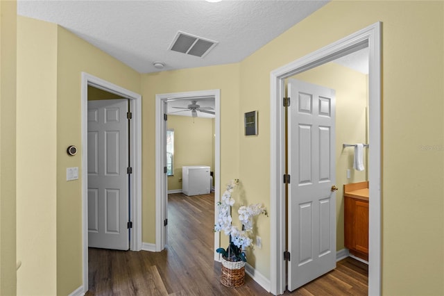 hallway with dark wood-type flooring and a textured ceiling