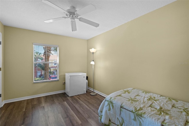 bedroom featuring a textured ceiling, dark hardwood / wood-style flooring, fridge, and ceiling fan