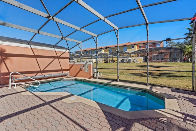 view of swimming pool featuring a patio area, a lanai, and a lawn