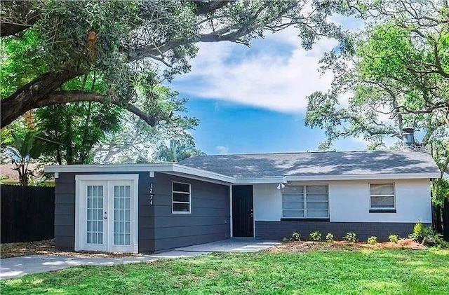 ranch-style house with french doors and a front yard