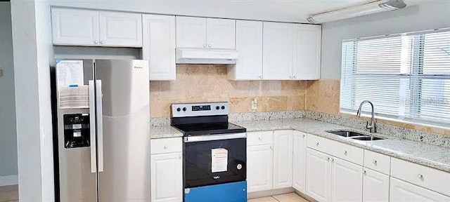 kitchen with backsplash, light stone counters, stainless steel appliances, sink, and white cabinets