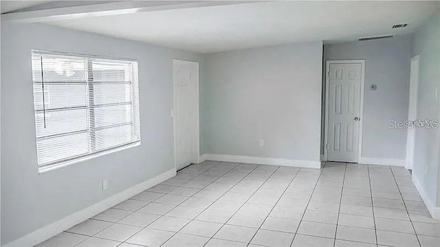 tiled spare room featuring a healthy amount of sunlight