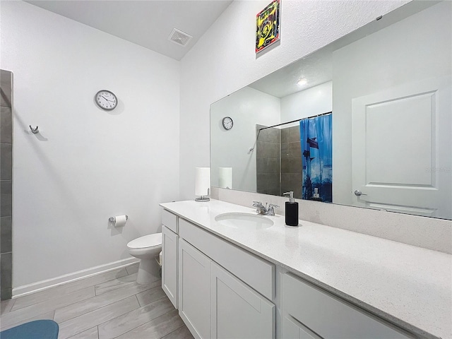 bathroom featuring hardwood / wood-style floors, vanity, toilet, and curtained shower