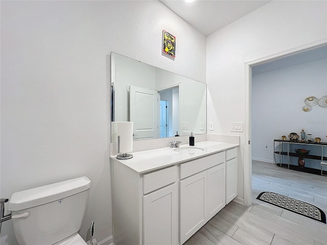 bathroom with hardwood / wood-style floors, vanity, and toilet