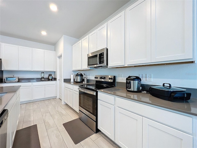 kitchen featuring white cabinetry, stainless steel appliances, and light wood-type flooring