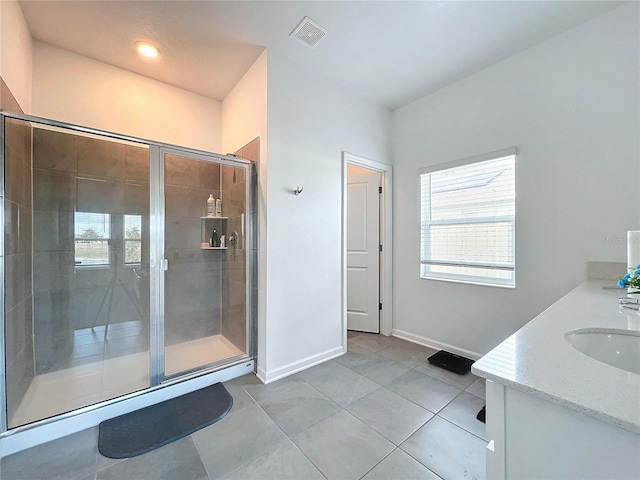 bathroom featuring tile patterned flooring, vanity, and a shower with door