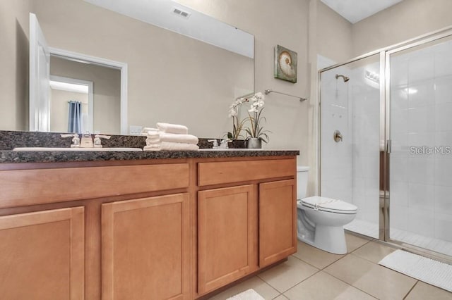 bathroom featuring tile patterned floors, vanity, toilet, and walk in shower