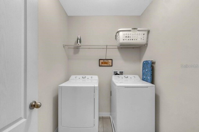 laundry area featuring light tile patterned flooring and washing machine and dryer