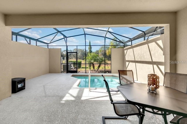 view of pool featuring glass enclosure and a patio