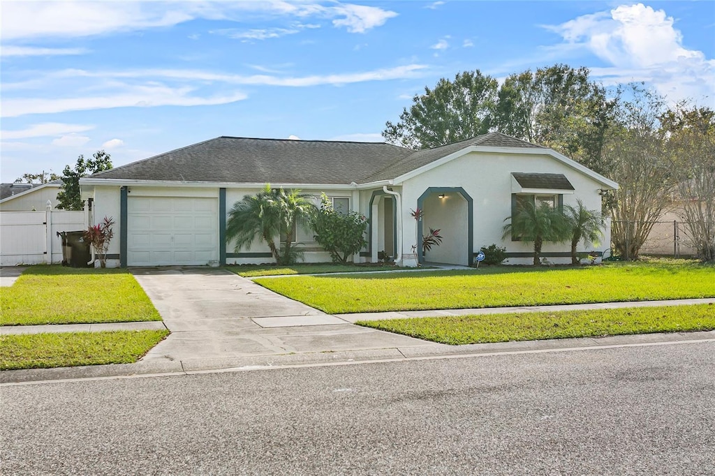 single story home featuring a garage and a front lawn