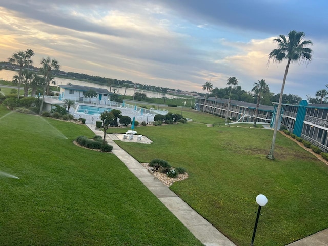 view of community with a pool and a yard