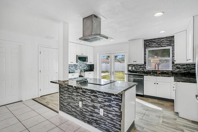 kitchen featuring white cabinetry, sink, stainless steel appliances, light tile patterned floors, and exhaust hood