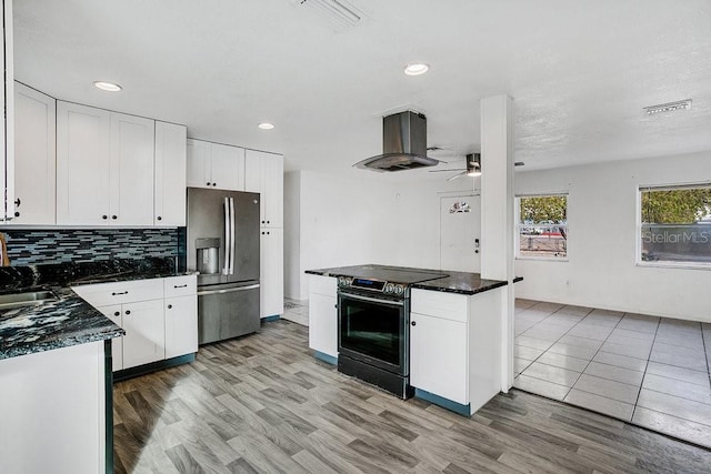 kitchen with island exhaust hood, stainless steel fridge, white cabinets, ceiling fan, and black electric range