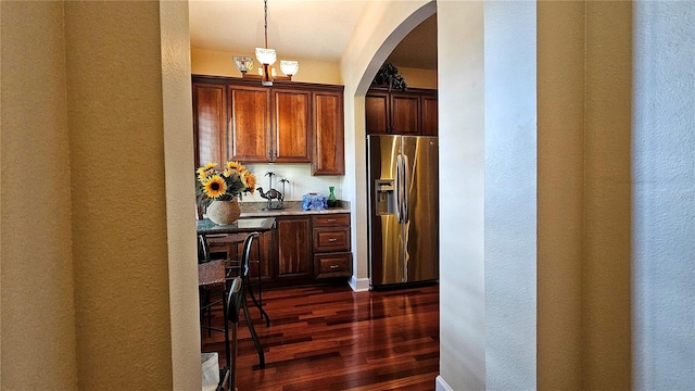 kitchen featuring dark hardwood / wood-style flooring, pendant lighting, and stainless steel refrigerator with ice dispenser