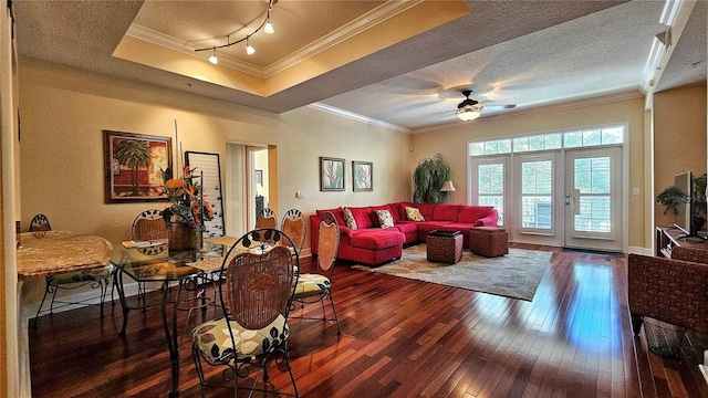 living room featuring dark hardwood / wood-style floors, ceiling fan, crown molding, and a textured ceiling