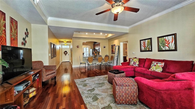 living room with dark hardwood / wood-style flooring, a textured ceiling, and ornamental molding