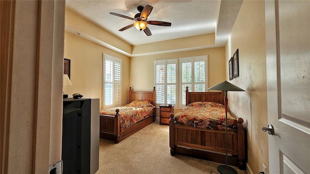 carpeted bedroom featuring ceiling fan and a textured ceiling