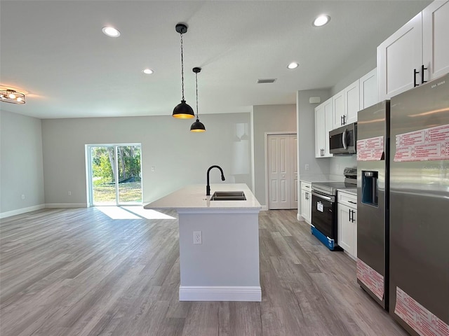 kitchen featuring white cabinets, decorative light fixtures, stainless steel appliances, and sink