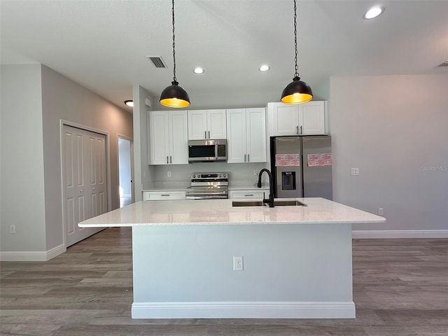 kitchen featuring pendant lighting, a center island with sink, white cabinets, sink, and stainless steel appliances