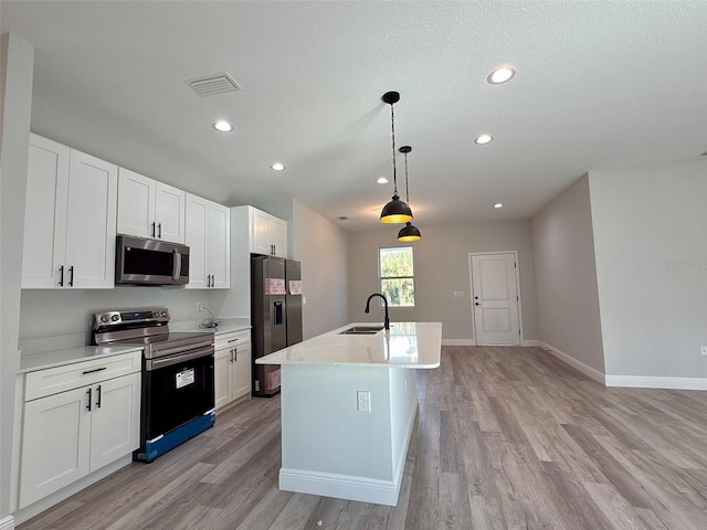 kitchen featuring stainless steel appliances, white cabinetry, hanging light fixtures, and sink