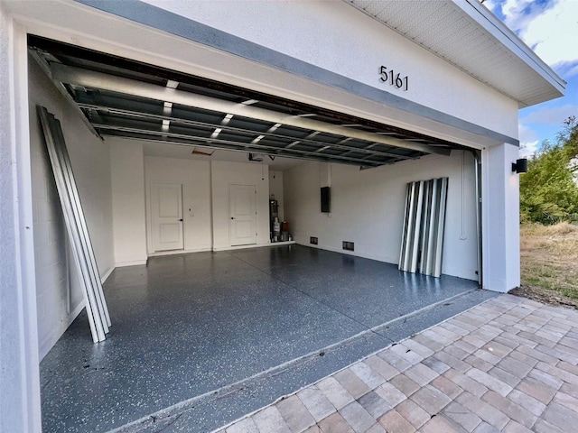 garage featuring electric panel and a carport