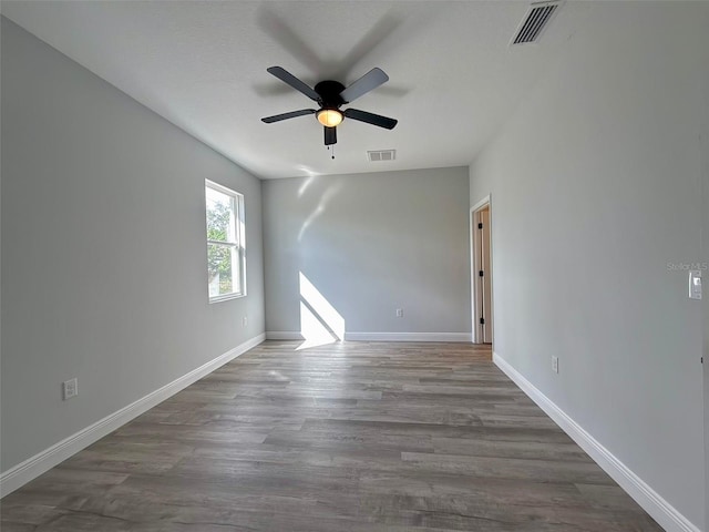 empty room with ceiling fan and dark hardwood / wood-style floors