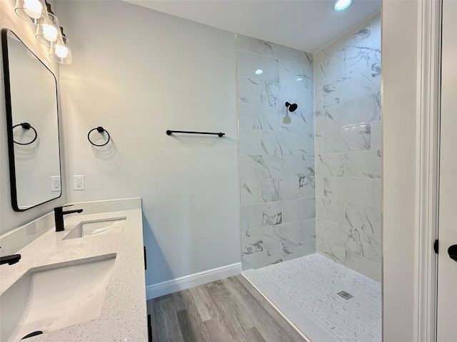 bathroom with vanity, wood-type flooring, and tiled shower