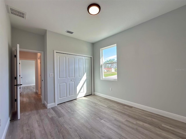 unfurnished bedroom featuring light hardwood / wood-style flooring and a closet