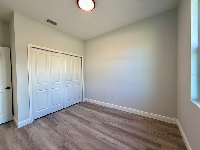 unfurnished bedroom featuring light wood-type flooring and a closet