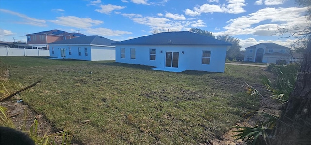 rear view of house featuring a yard