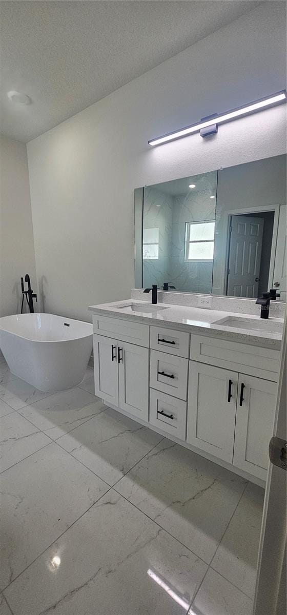 bathroom with a bathtub, vanity, and a textured ceiling