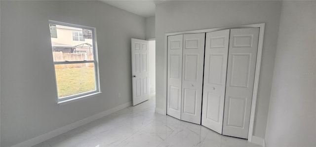 unfurnished bedroom featuring a closet and multiple windows