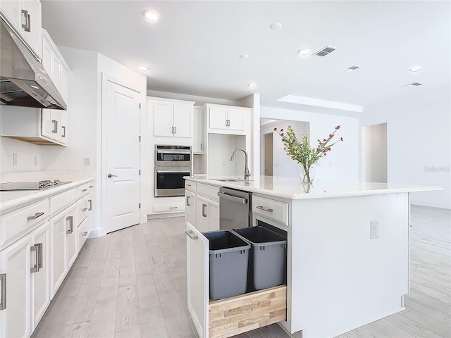 kitchen with sink, an island with sink, appliances with stainless steel finishes, light hardwood / wood-style floors, and white cabinetry