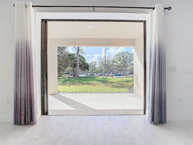 doorway featuring a wealth of natural light and light hardwood / wood-style flooring